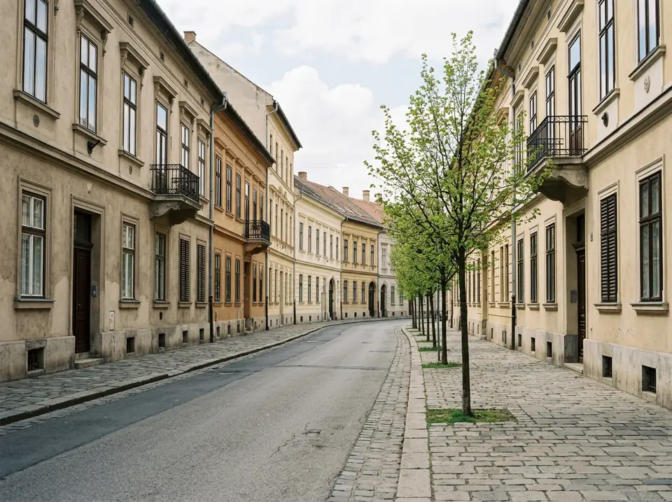 Belvárosi utca kétszintes, vakolt homlokzatú lakóházakkal, széles járdával